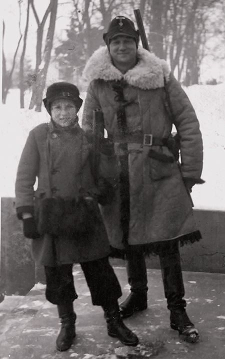 Historisches Bild aus den Vierziger Jahren zu sehen ist Ein Mann und ein Bub in dicker Winterkleidung vor winterlicher Landschaft.