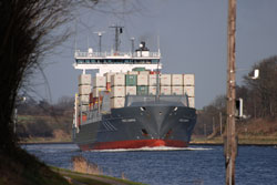 Auf dem Bild ist ein beladenes Containerschiff auf dem Nord-Ostsee-Kanal zu sehen.