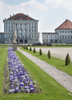 Schloss Nymphenburg mit Beeten voller Zierpflanzen.