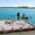 Ein von der LBV-Kreisgruppe Neu-Ulm neu gebautes Brutfloß für Flussseeschwalben am Wullenstettener Baggersee wird ins Wasser gelassen (Foto: Franz Zeller).