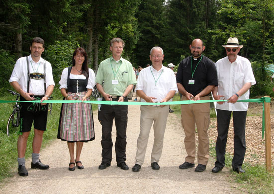 Die Projektpartner eröffnen den Moorerlebnisweg, indem sie ein grünes Band durchschneiden.