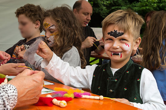 Die Kinder beim Basteln und Schminken.