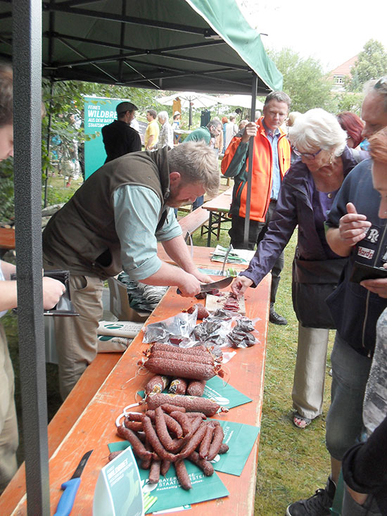 Besucher probieren Wurstprodukte aus Wildfleisch.