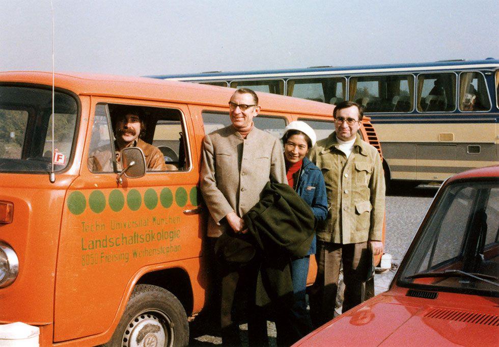 Historisches Foto aus den Siebziger Jahren mit mehreren Personen vor einem VW Bus.