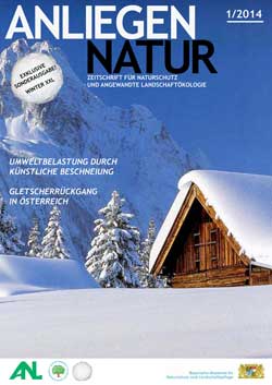Almhütte mit Bäumen im Schnee, im Hintergrund Hochgebirge.