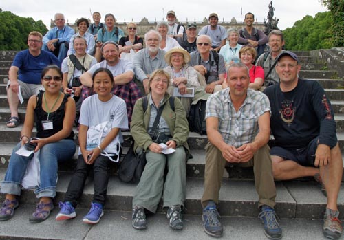 Lachende Teilnehmergruppe auf einer Treppe sitzend.