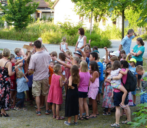 Zahlreiche Kinder versammeln sich, um die Anleitung zur Schatzsuche zu bekommen.