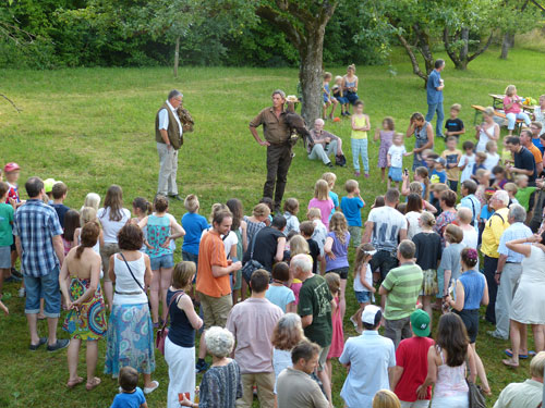 Zahlreiche Besucher versammeln sich um den Greifvogelexperten vom Adlergehege Berchtesgadener Land (BGD).