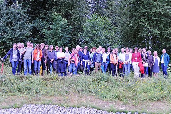 Gruppenfoto aller Exkursionsteilnehmer oberhalb des Nährstoffrückhaltebeckens, im Hintergrund Wald.