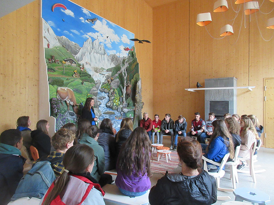 Die Erasmus-Schüler im Haus der Berge, sitzend vor einer großen, dreidimensionalen Abbildung des Nationalparks Berchtesgaden aus Holz.