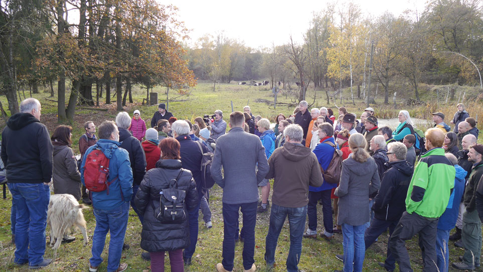 Eine Gruppe von Menschen steht an einer Weidefläche im Zuge einer Exkursion in die Mühldorfer Kiesgrube.